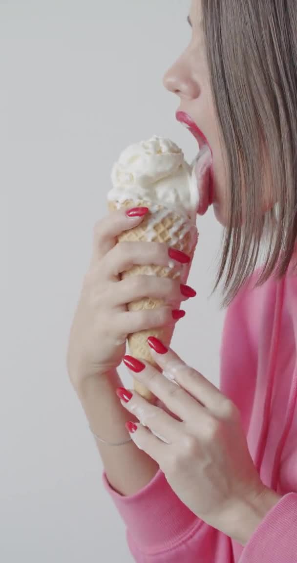 Молодая женщина ест мороженое — стоковое видео