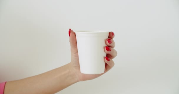 Burla de la mano femenina sosteniendo taza de papel de café — Vídeos de Stock
