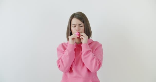 Giovane donna che soffia un palloncino rosa — Video Stock