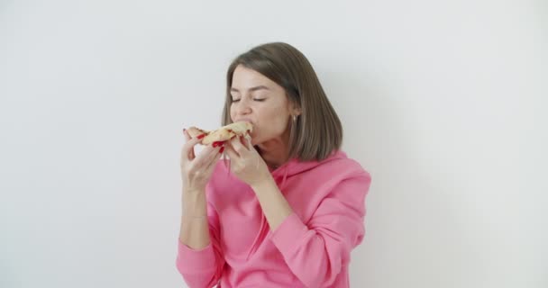 Jonge vrouw die pizza eet — Stockvideo