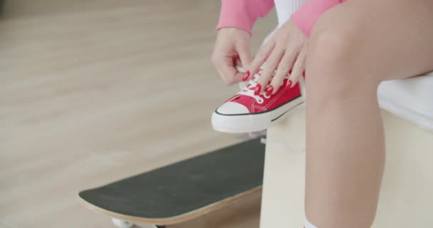 Νεαρή γυναίκα skateboarder δένοντας κορδόνια — Αρχείο Βίντεο
