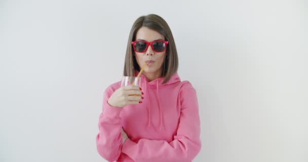 Güneş gözlüklü kız meyve suyu içiyor. — Stok video