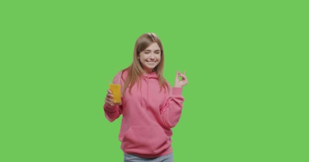 Genç ve güzel bir kadın portakal suyu içiyor. — Stok video