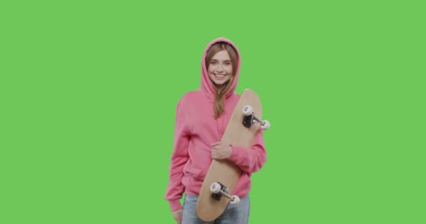 Frau im rosafarbenen Kapuzenpullover mit Skateboard — Stockvideo