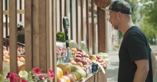 Jóvenes eligiendo frutas en kiosco callejero — Vídeos de Stock