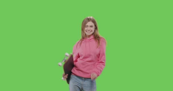 스케이트보드를 들고 있는 분홍색 후드를 쓴 여자 — 비디오