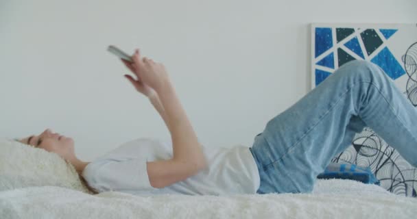 Teenie-Mädchen fällt zu Hause auf ein Bett — Stockvideo