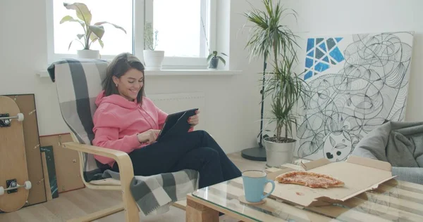 Mulher relaxante em casa segurando tablet digital — Fotografia de Stock