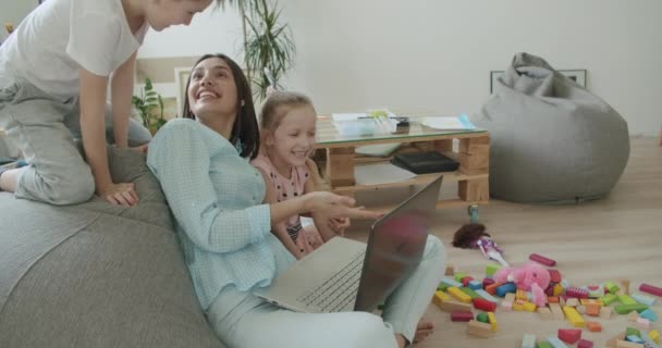 Счастливые мамы и милые дети, пользующиеся ноутбуком дома — стоковое видео