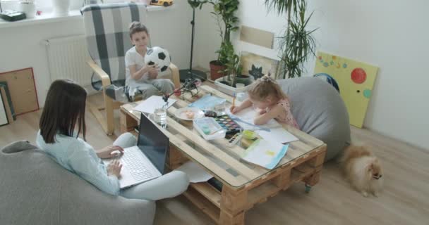 Onnellinen äiti ja söpö lapset käyttävät kannettavaa tietokonetta kotona — kuvapankkivideo