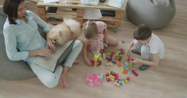 Feliz mamá y los niños lindos usando el ordenador portátil en casa — Vídeos de Stock