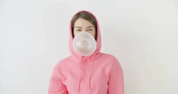 Girl dressed in pink hoodie blowing bubblegum — Stock Photo, Image