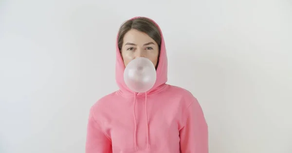 Girl dressed in pink hoodie blowing bubblegum — Stock Photo, Image