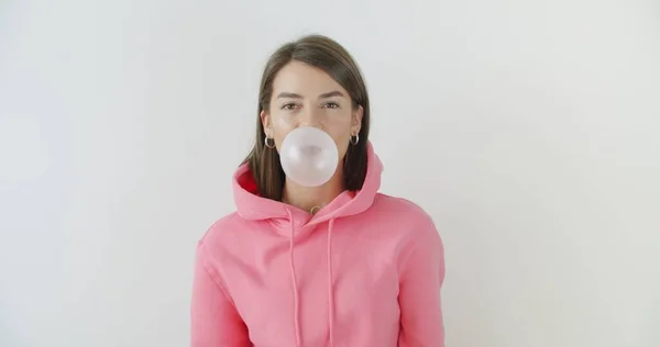 Girl dressed in pink hoodie blowing bubblegum — Stock Photo, Image