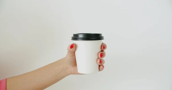 Mockup de mão feminina segurando xícara de papel de café — Fotografia de Stock