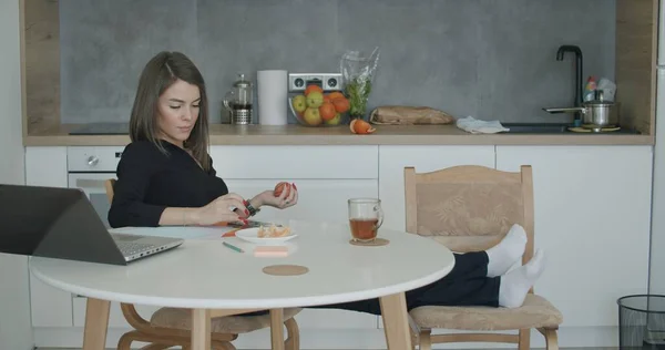Evraklarla çalışan bir kadın mutfakta oturuyor.. — Stok fotoğraf