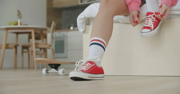 Молодая женщина скейтбордист завязывая шнурки — стоковое фото