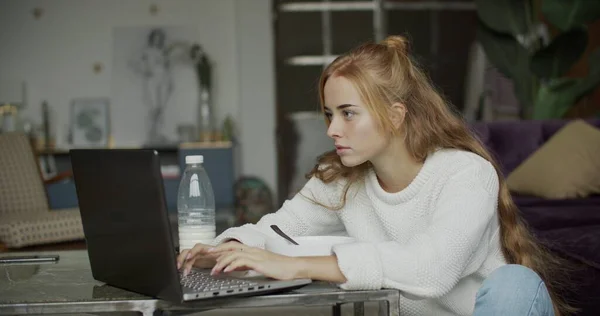 Молодая женщина с помощью телефона и компьютера в доме — стоковое фото