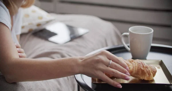 Menina deitada na cama tomando café da manhã — Fotografia de Stock