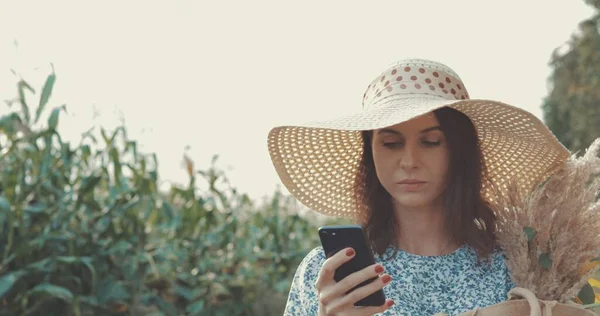 Vrouw neemt selfie op telefoon bij zonnebloem veld — Stockfoto