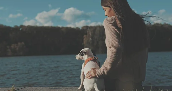 Köpeğiyle gölde oturan kadın. — Stok fotoğraf