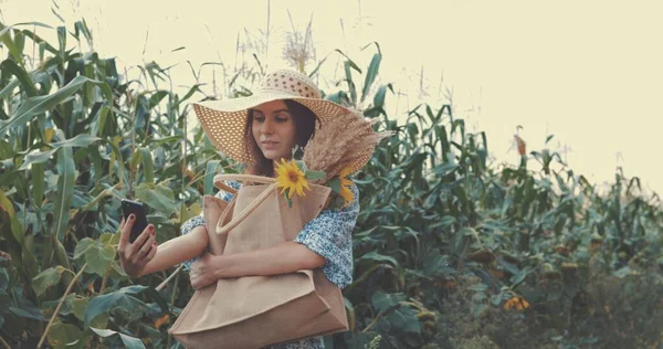 Frau macht Selfie mit Handy auf Sonnenblumenfeld — Stockfoto