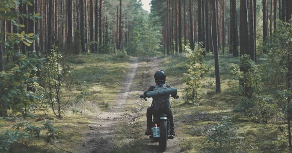 Junger Fahrer fährt Motorrad auf Forststraße — Stockfoto