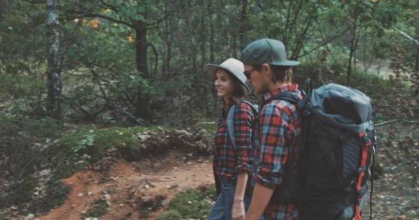 Ung man och kvinna vandring i skogen — Stockfoto