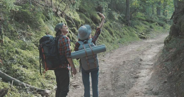 Genç bir adam ve bir kadın ormanda yürüyüş yapıyor. — Stok fotoğraf