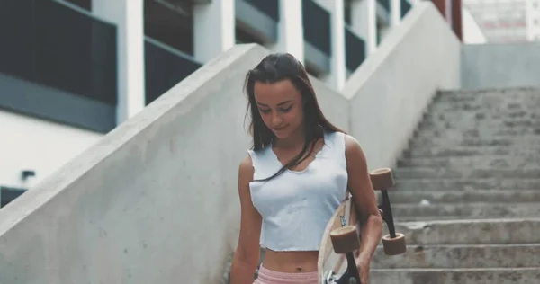 Молода дівчина йде сходами зі скейтбордом — стокове фото