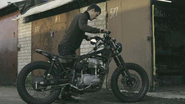 El tipo rueda la motocicleta en el garaje —  Fotos de Stock