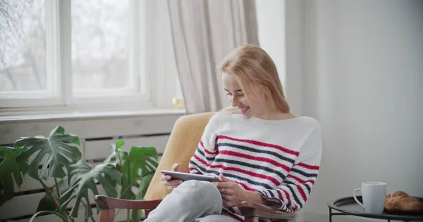 Mulher relaxante em casa segurando tablet digital — Fotografia de Stock