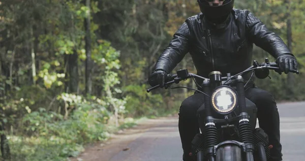 Guy rijden motorfiets op bosweg — Stockfoto