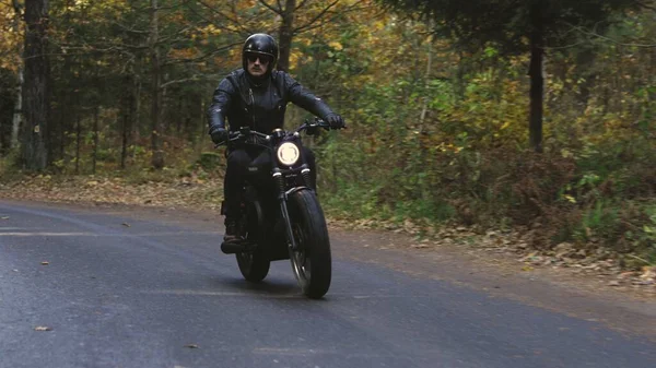 Facet jazda motocyklem po leśnej drodze — Zdjęcie stockowe