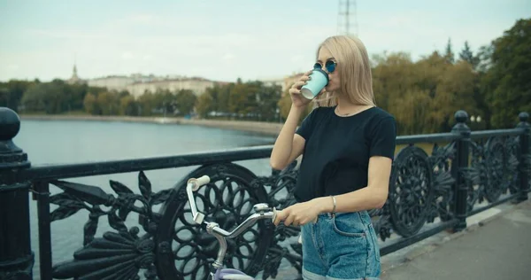 Ung kvinna promenader på stadens gator med cykel — Stockfoto