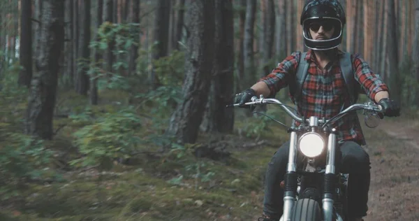 Mladý jezdec řízení motocykl na lesní cestě — Stock fotografie