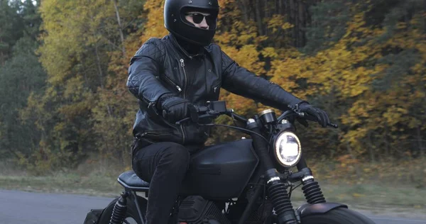 Kerl fährt Motorrad auf Waldstraße — Stockfoto