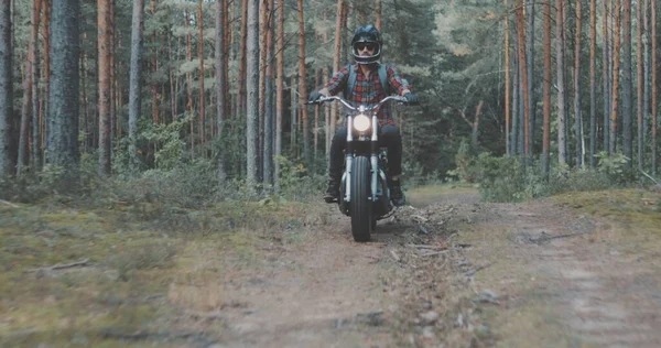 Junger Fahrer fährt Motorrad auf Forststraße — Stockfoto