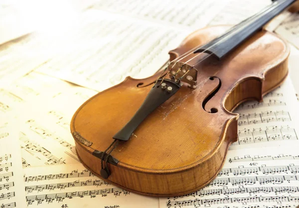 Стара скрипка лежить на аркуші музики — стокове фото