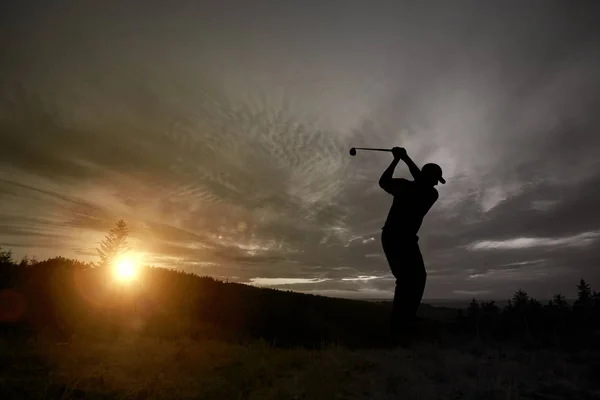 高尔夫球手打高尔夫球日落期间在竞争事件 — 图库照片