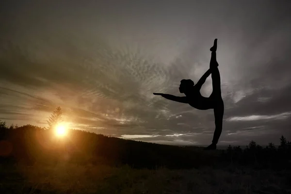 Praticante de ioga durante o pôr do sol — Fotografia de Stock