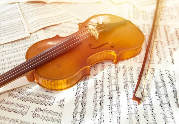 Oude viool liggend op het blad van de muziek — Stockfoto