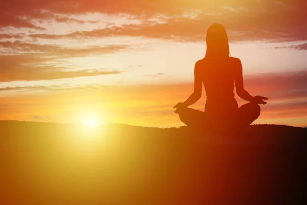 Yoga practicioner under solnedgången — Stockfoto