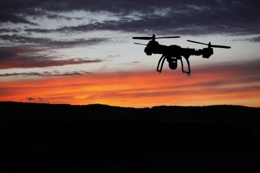 Yenilik kavramı. Günbatımı üzerinde uçan uçak silueti. Ağır dron fotoğraf çekme Kaldır
