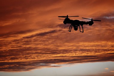 Yenilik kavramı. Günbatımı üzerinde uçan uçak silueti. Ağır dron fotoğraf çekme Kaldır