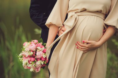 Hamile kadın parlak kokulu çiçek ve kocası karın açık havada sarılma. Gebelik, ebeveynlik, hazırlık ve beklenti kavramı