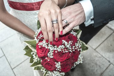 Karı koca elele alyans ile bir buket çiçek