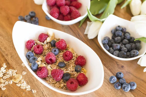  Granola Ahududu ve ahşap bir masa üzerinde yaban mersini ile Kahvaltı