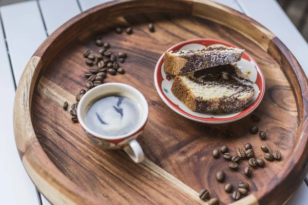 Bir fincan espresso ve ahşap bir masa üzerinde bir pasta 