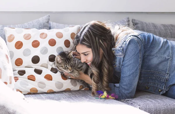 Kadın kanepe oturma odasında onu kedi ile oynarken